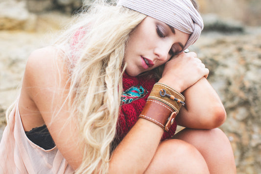 A simple guide to creating a Boho style bracelet. The guide shows a layout of materials like beads of various shapes, colors and sizes, leather strips, metal charms and clasps. The process is step by
