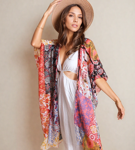 Woman wearing a colorful floral kimono and white dress against a beige background